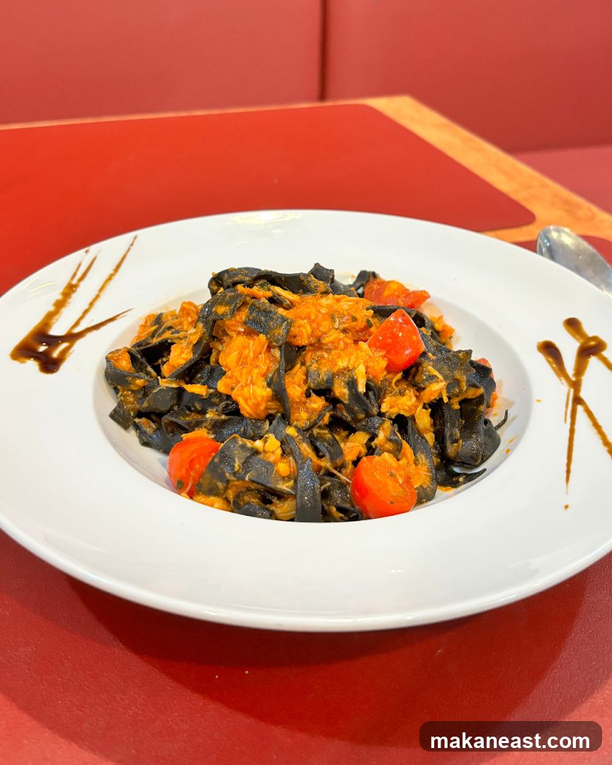 Black pasta with tomato sauce and cherry tomatoes