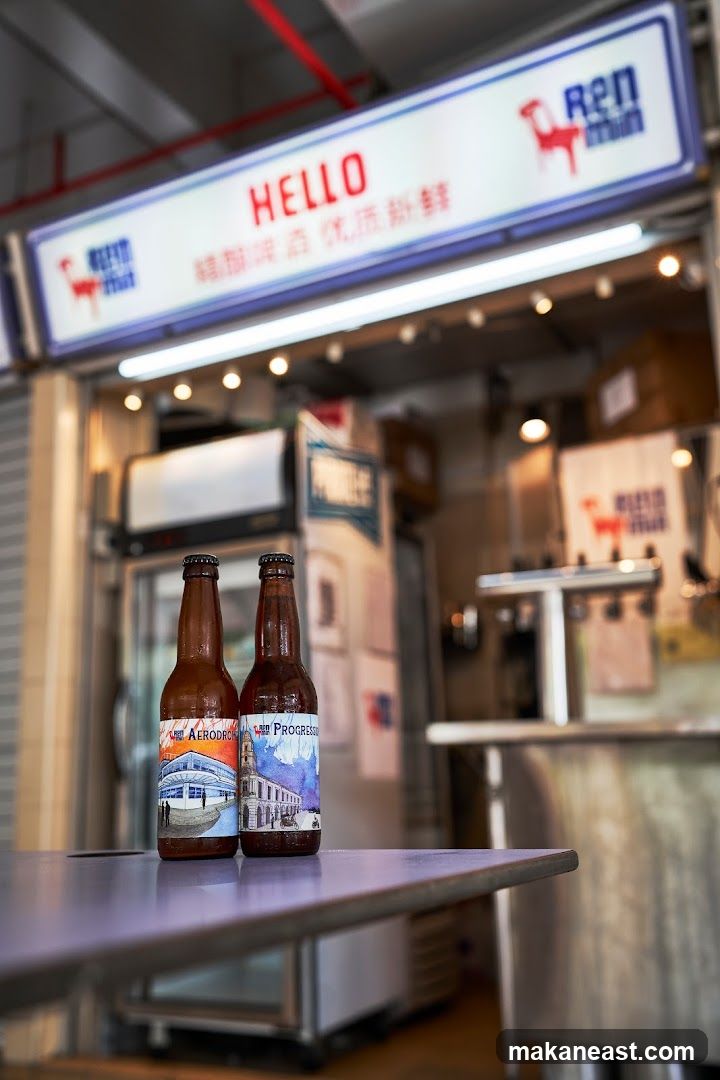 Two bottles of beer on a table in front of a shop