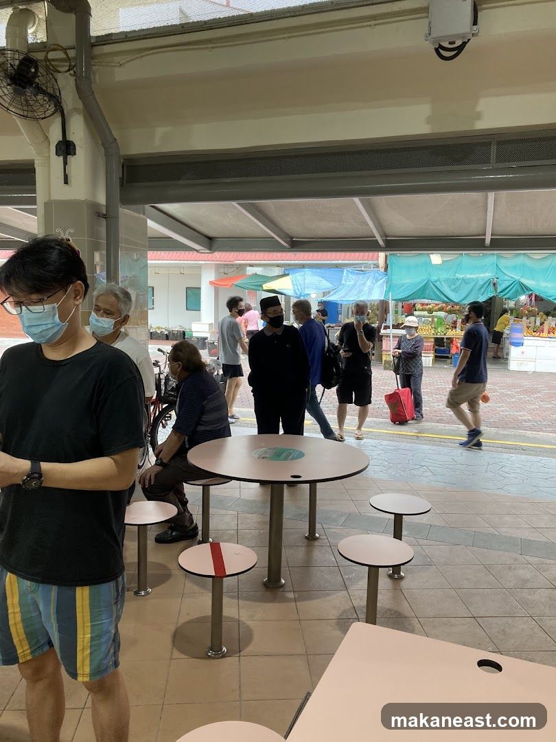 Outdoor food court with people and stalls