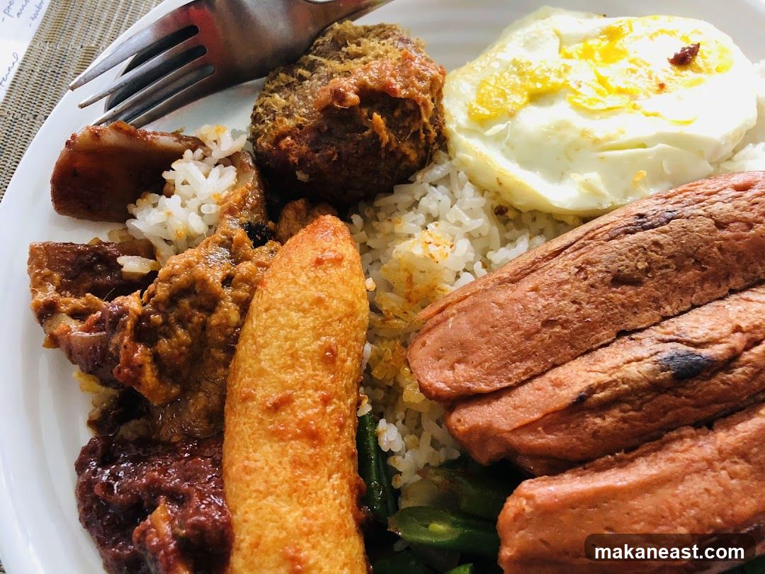 Plate of food with rice, fried egg, sausages, and other dishes
