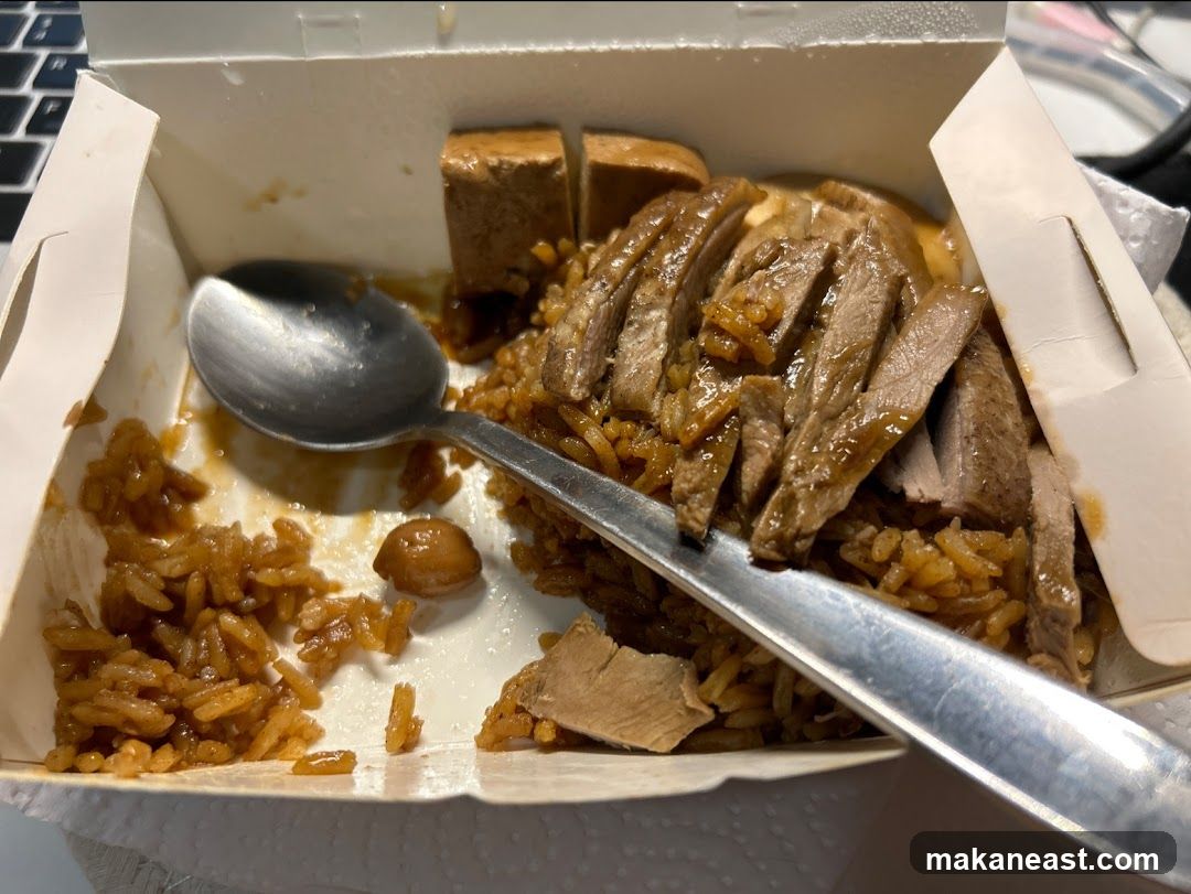 Sliced meat and rice in a takeout box