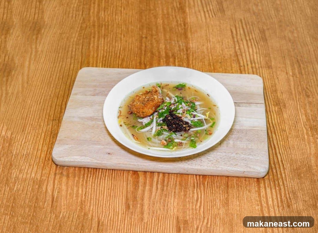 Bowl of noodle soup with fried item