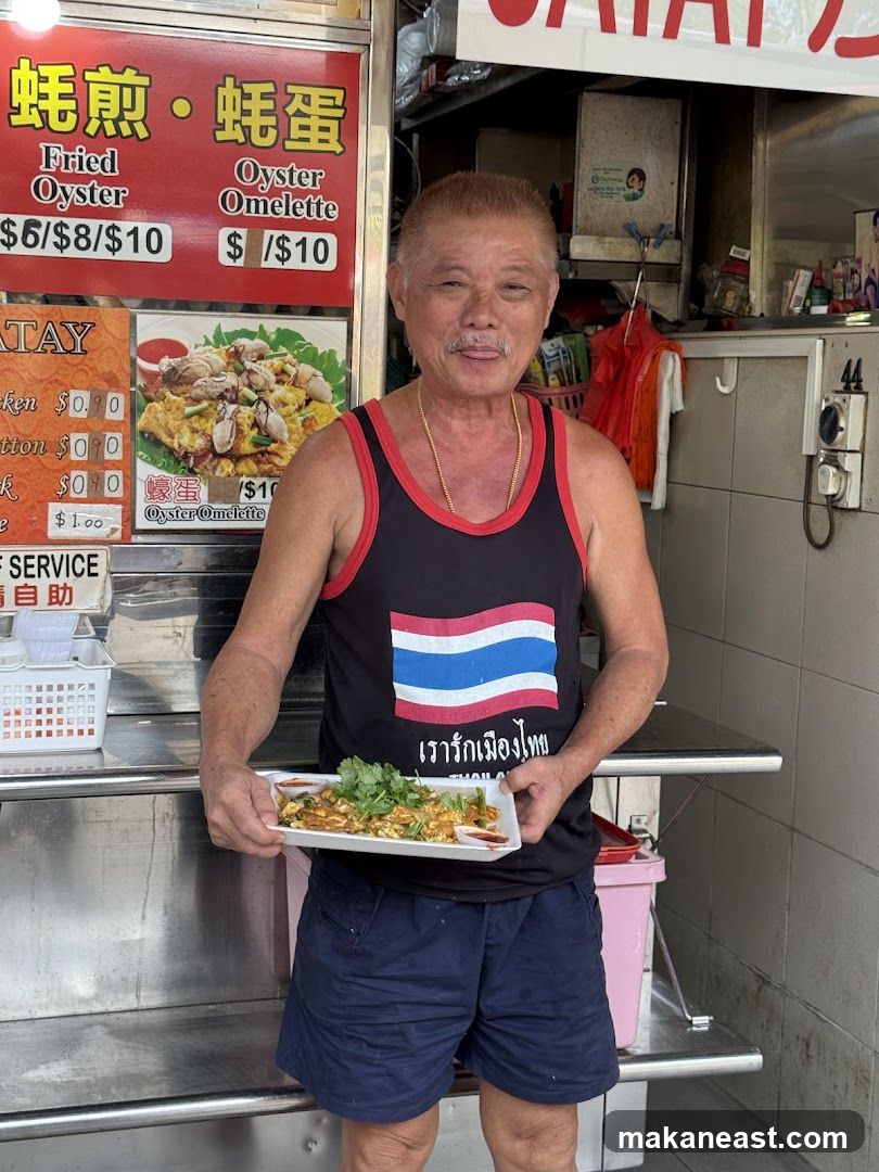 Man holding a plate of oyster omelette