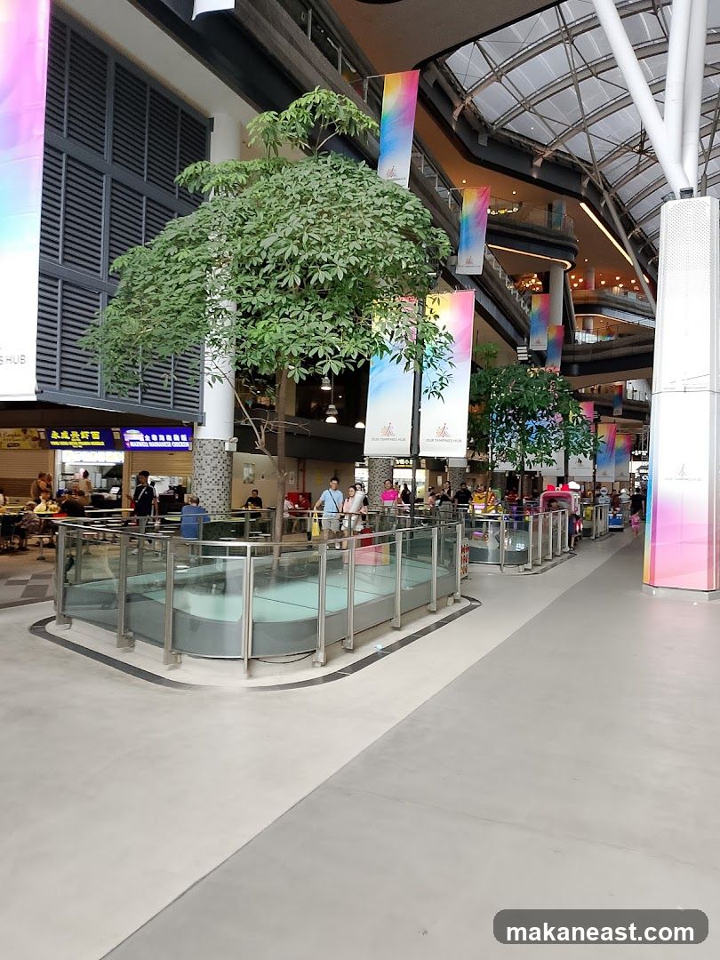 Indoor shopping mall atrium with greenery and banners
