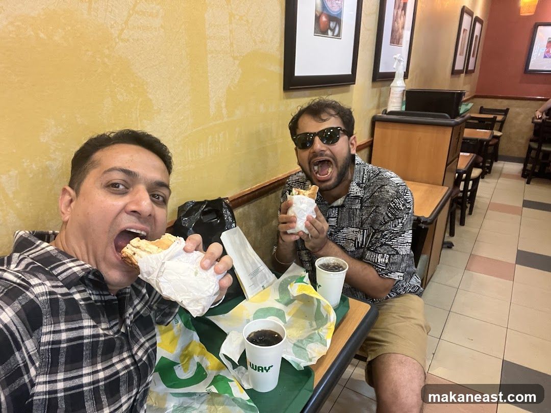 Two men eating sandwiches