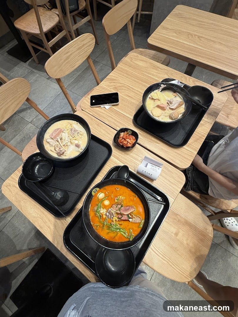 Two bowls of soup with meat and vegetables, and a side of kimchi