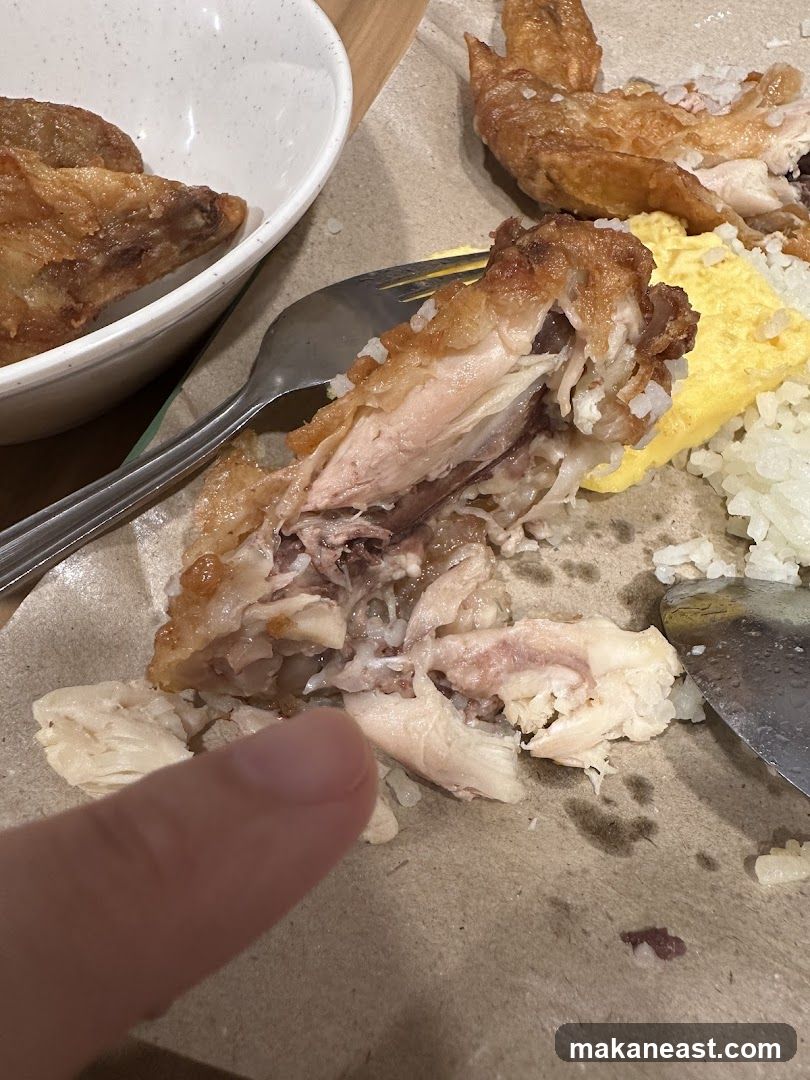 Close-up of a partially eaten chicken dish with rice and scrambled eggs