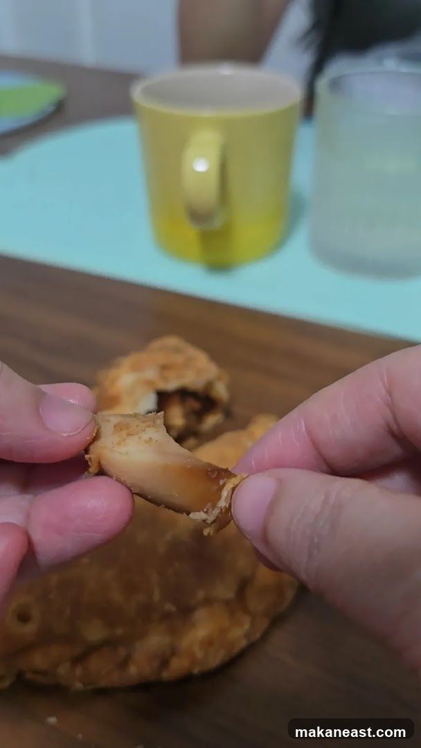 Close-up of hands holding a piece of fried food