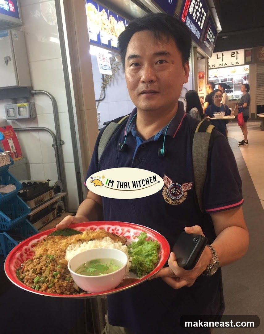 Man holding a tray of Thai food