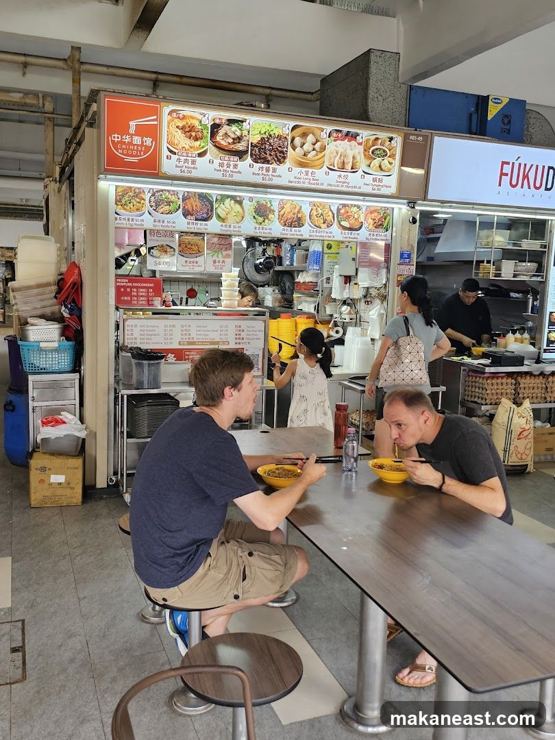 People Eating Noodles at a Food Stall