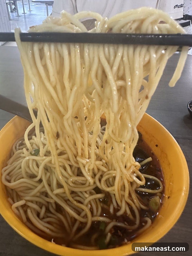 Noodles being lifted with chopsticks