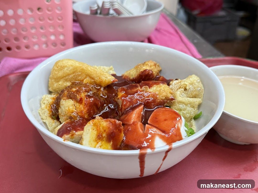 Bowl of food with sauce and a side of soup