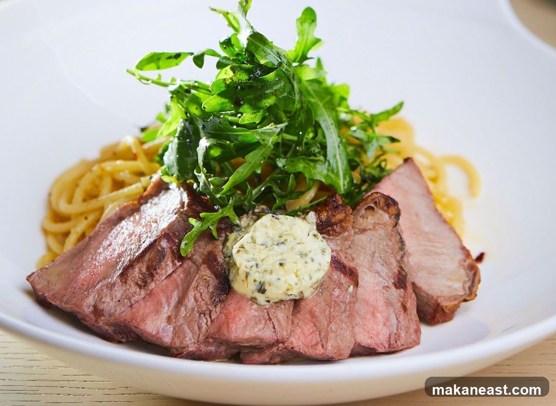 Sliced steak with pasta and greens