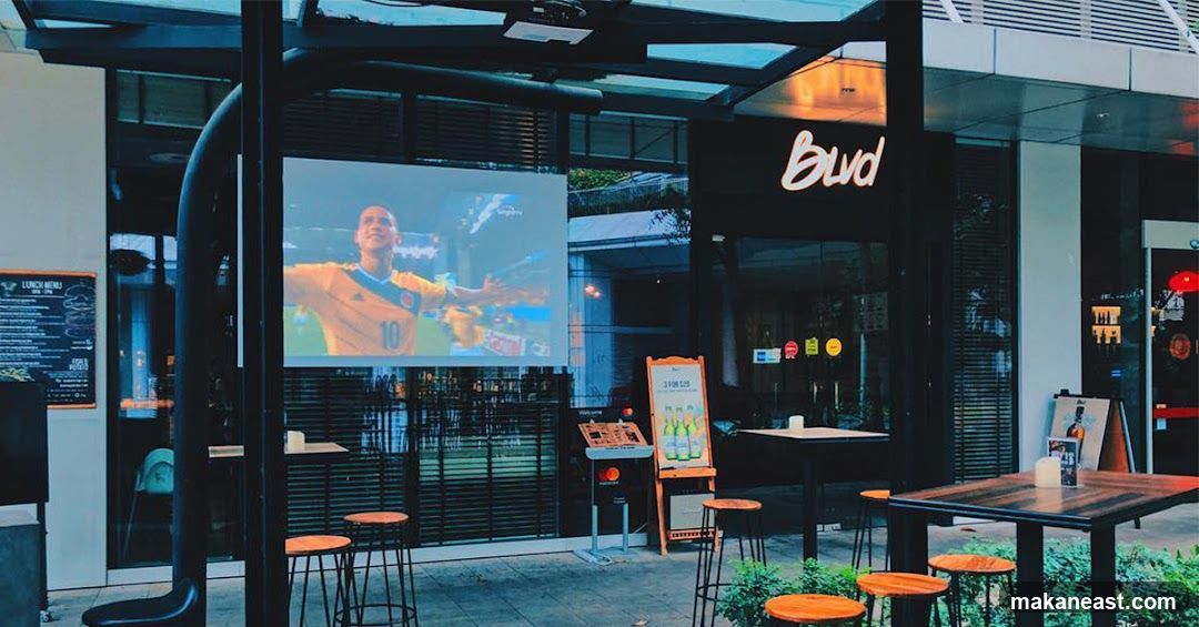 Outdoor seating area with projected sports game