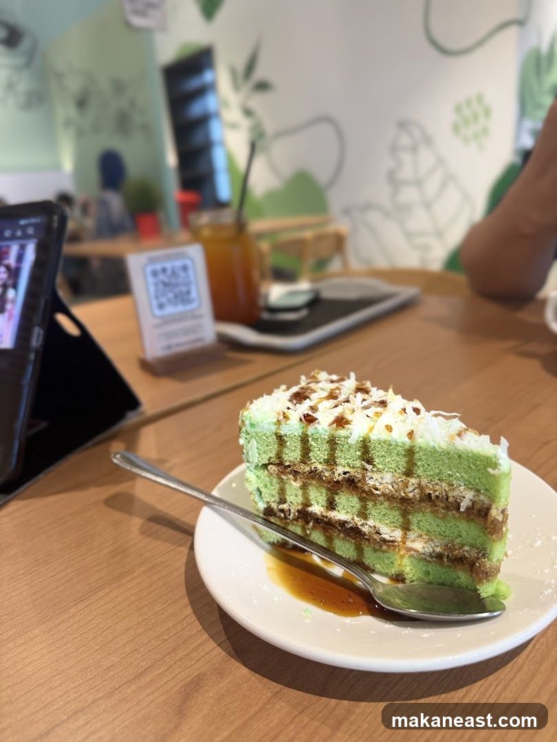 Slice of green cake with syrup and coconut