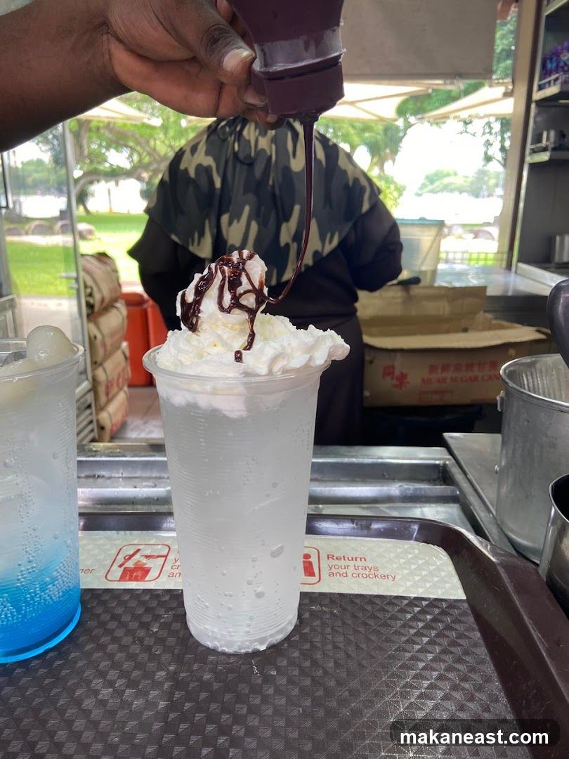 Chocolate Syrup Being Poured on Whipped Cream Topping