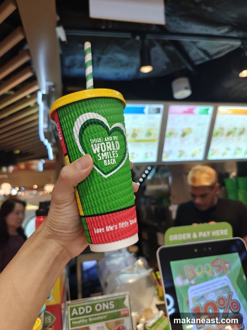 Person holding a cup with a straw