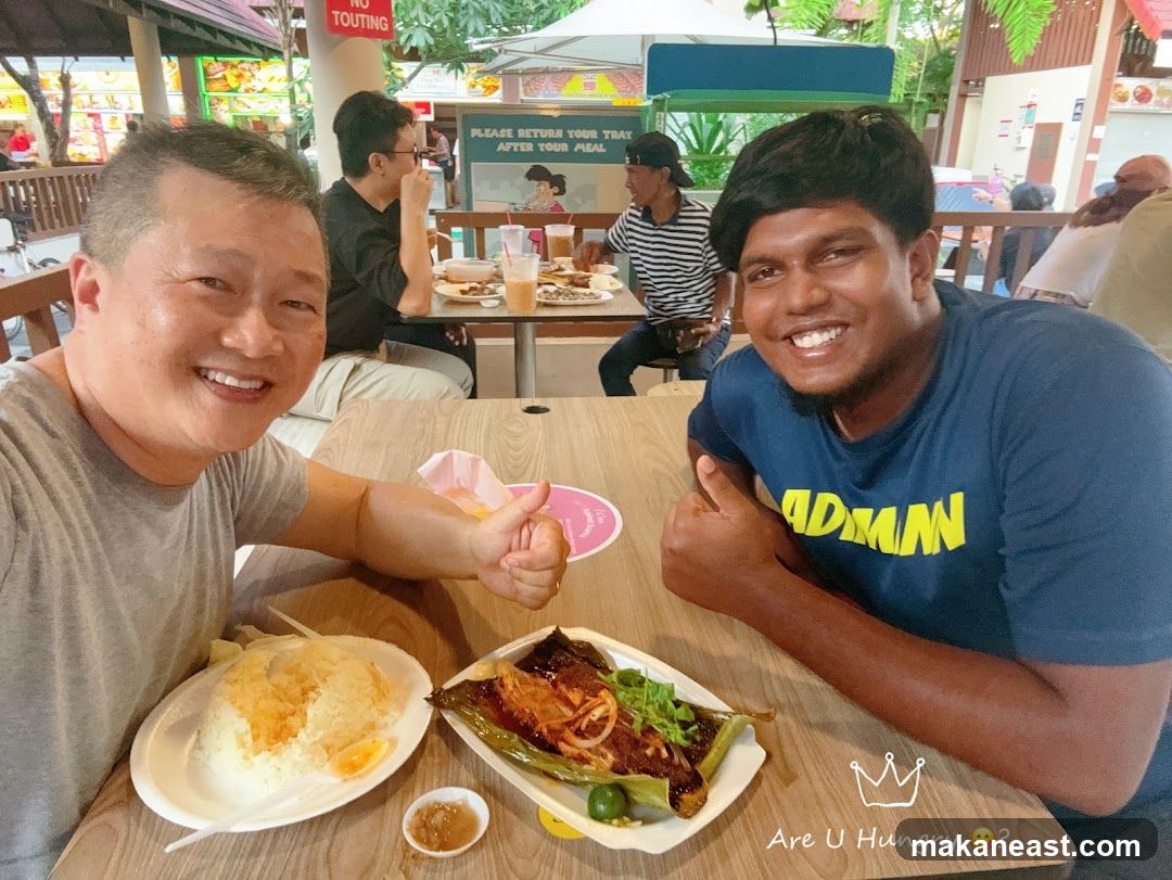 Two men enjoying a meal at a food court
