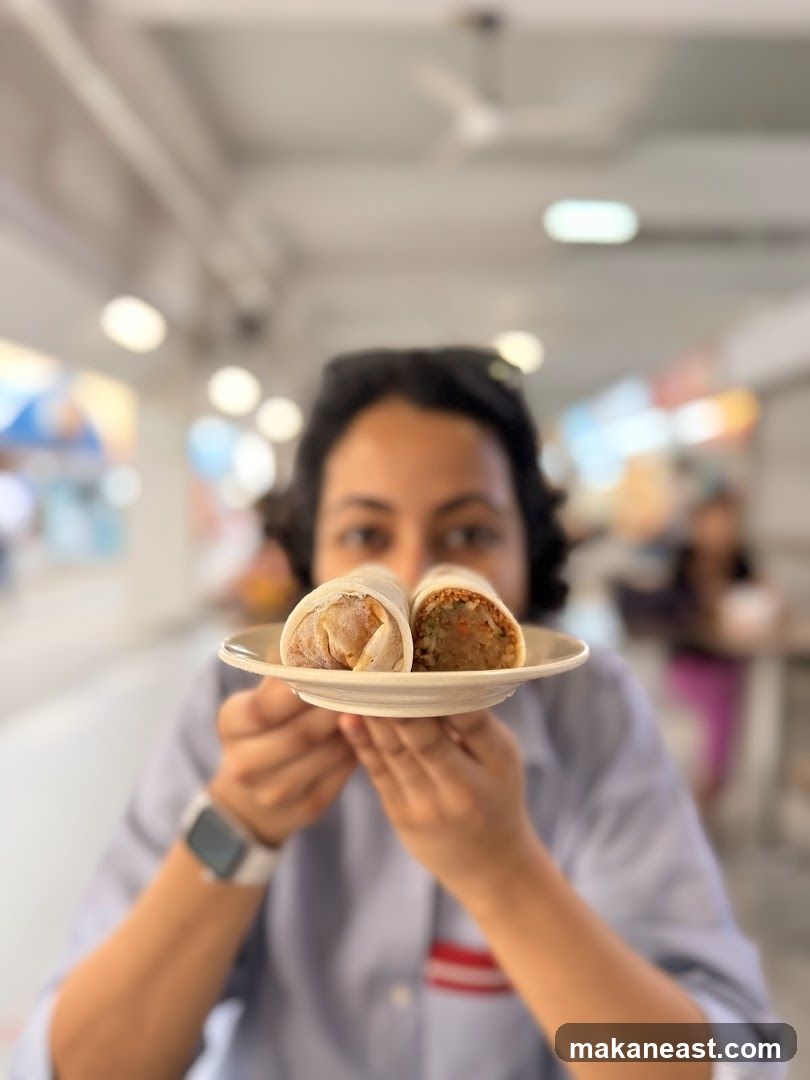Person holding two wraps on a plate