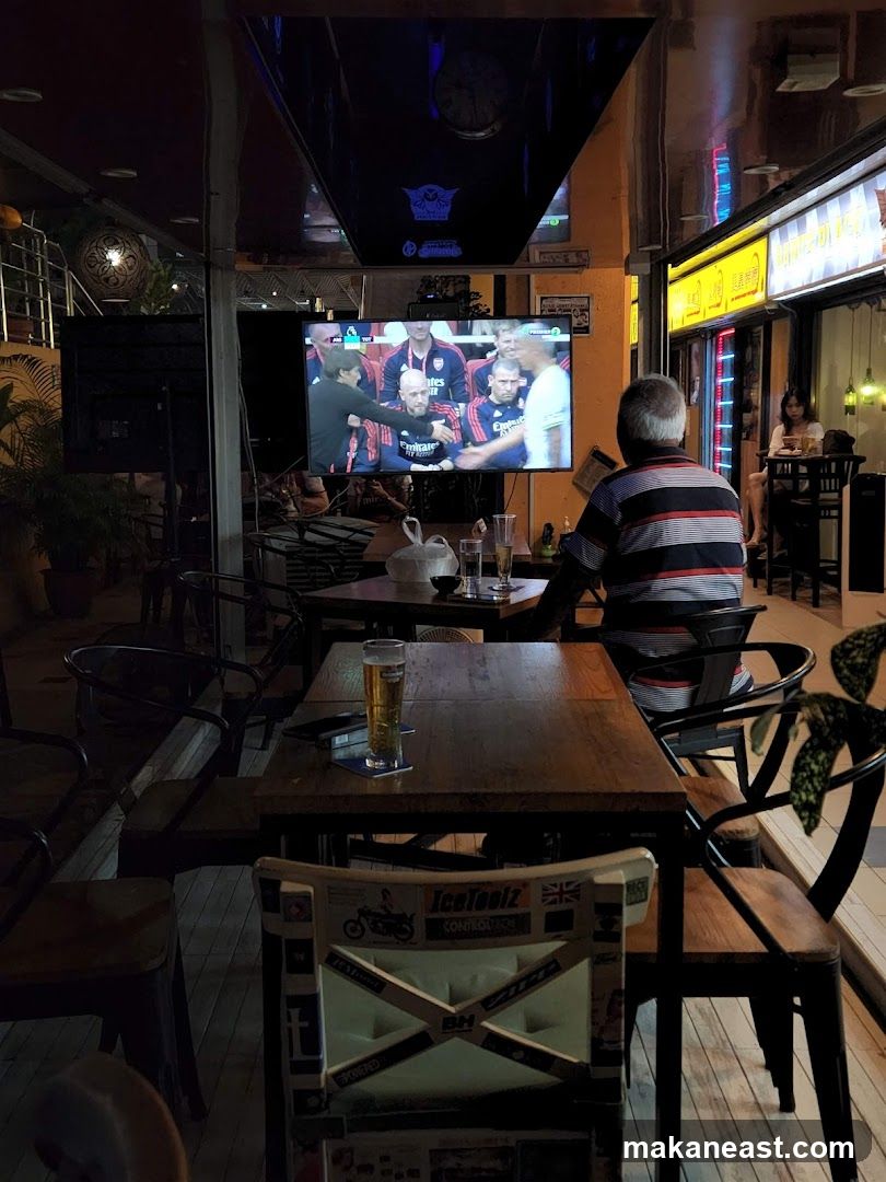 Bar with TV showing football match