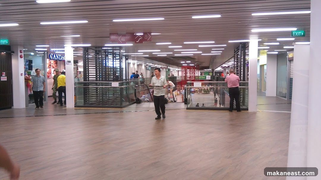 Busy indoor walkway with shops and escalators