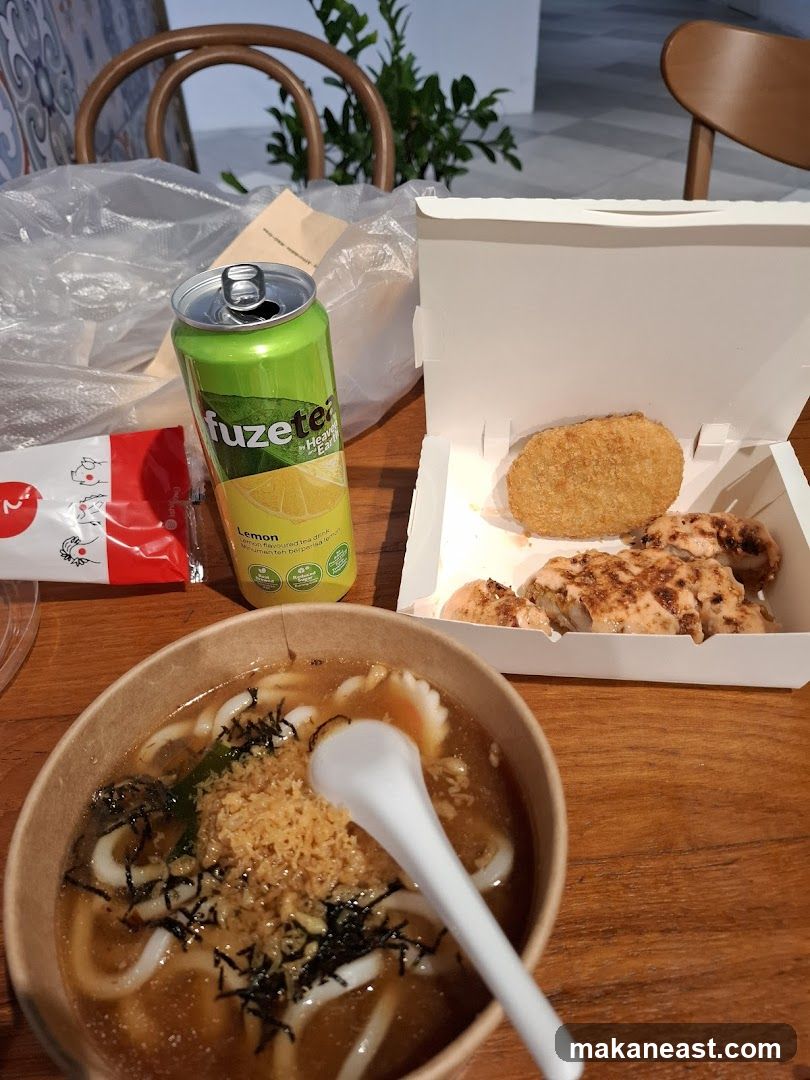 Udon noodles and grilled chicken with a can of iced tea