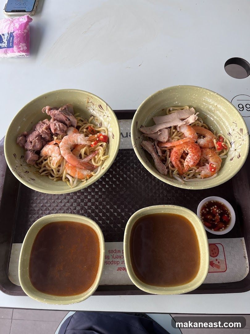 Two bowls of noodles with shrimp and meat