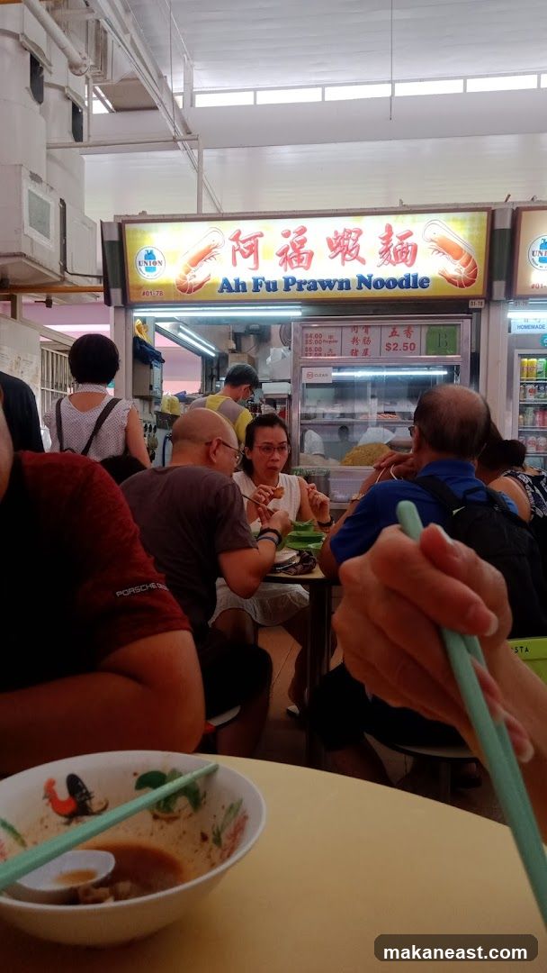 People eating at a noodle stall