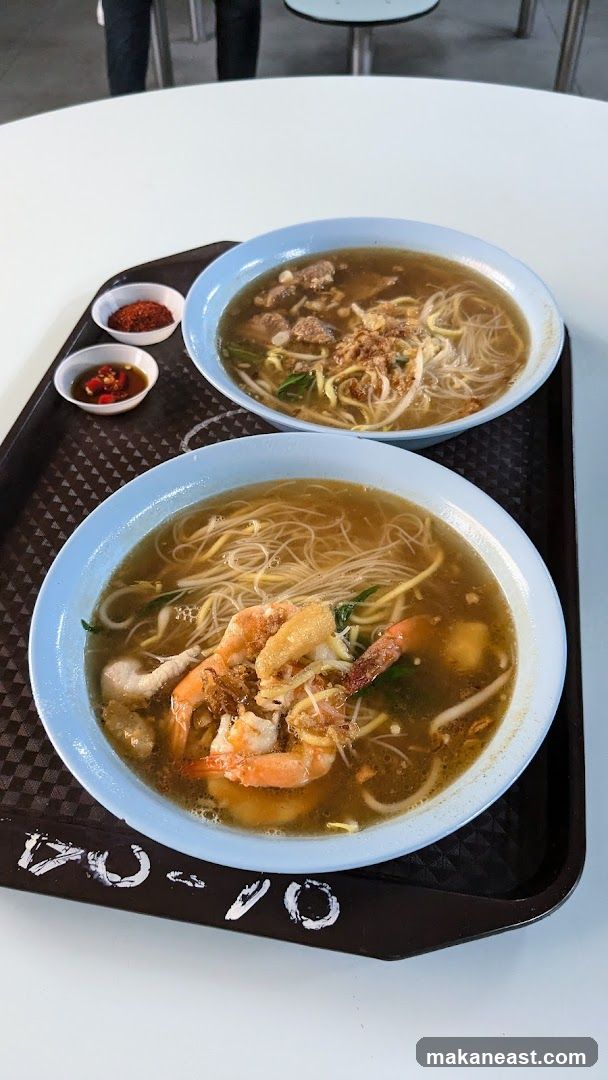Two bowls of noodles with shrimp and meat