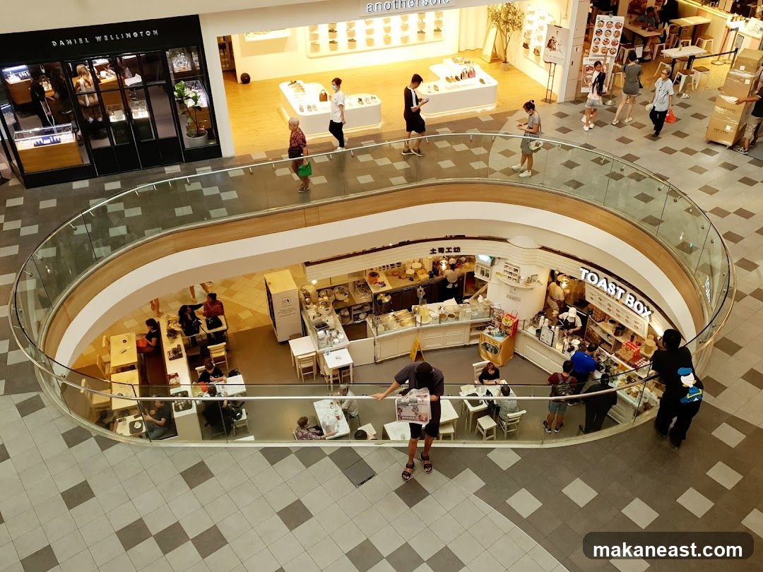 Shopping mall interior with various shops and cafes