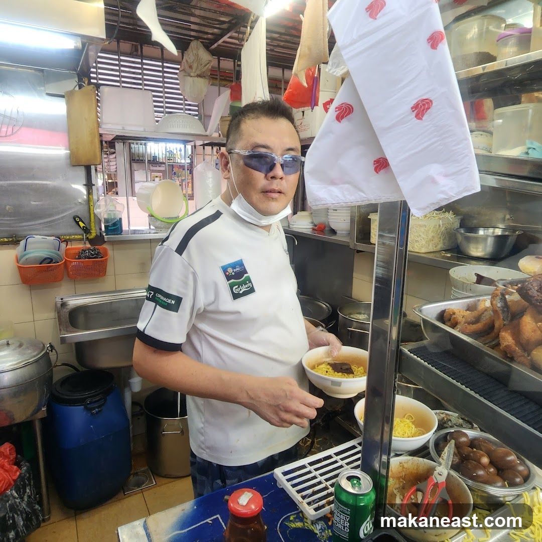 Man holding a bowl of noodles