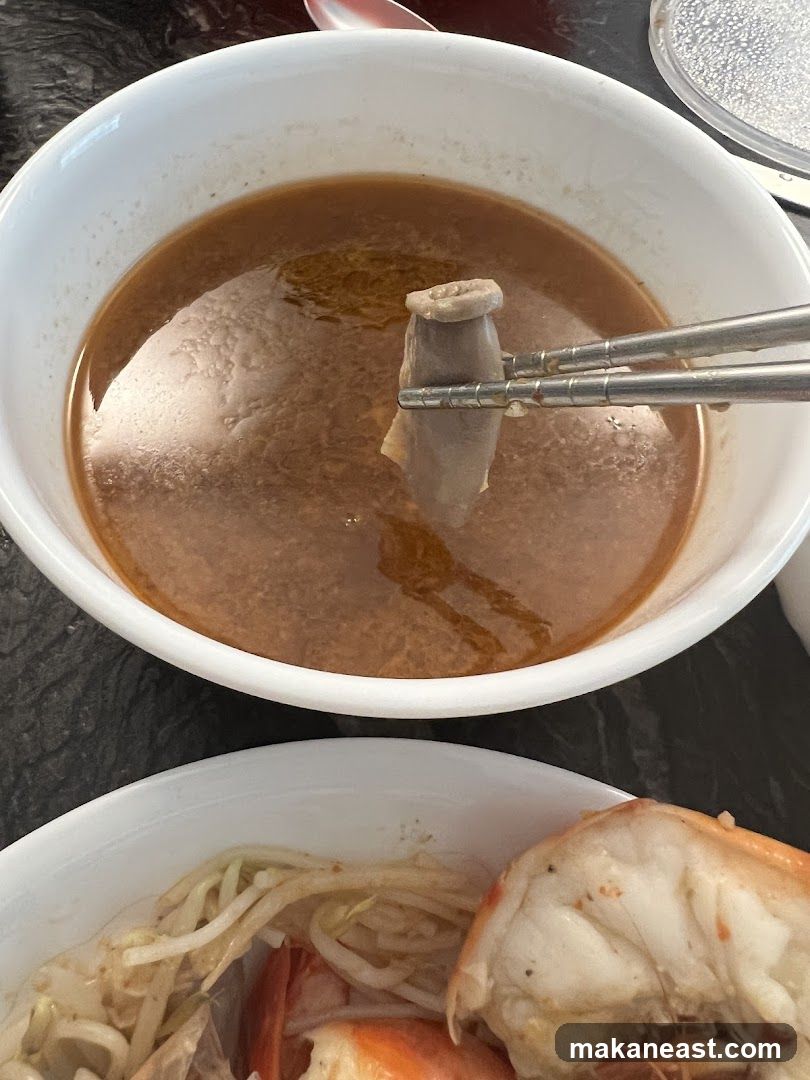 Close-up of a bowl of soup with intestines and shrimp