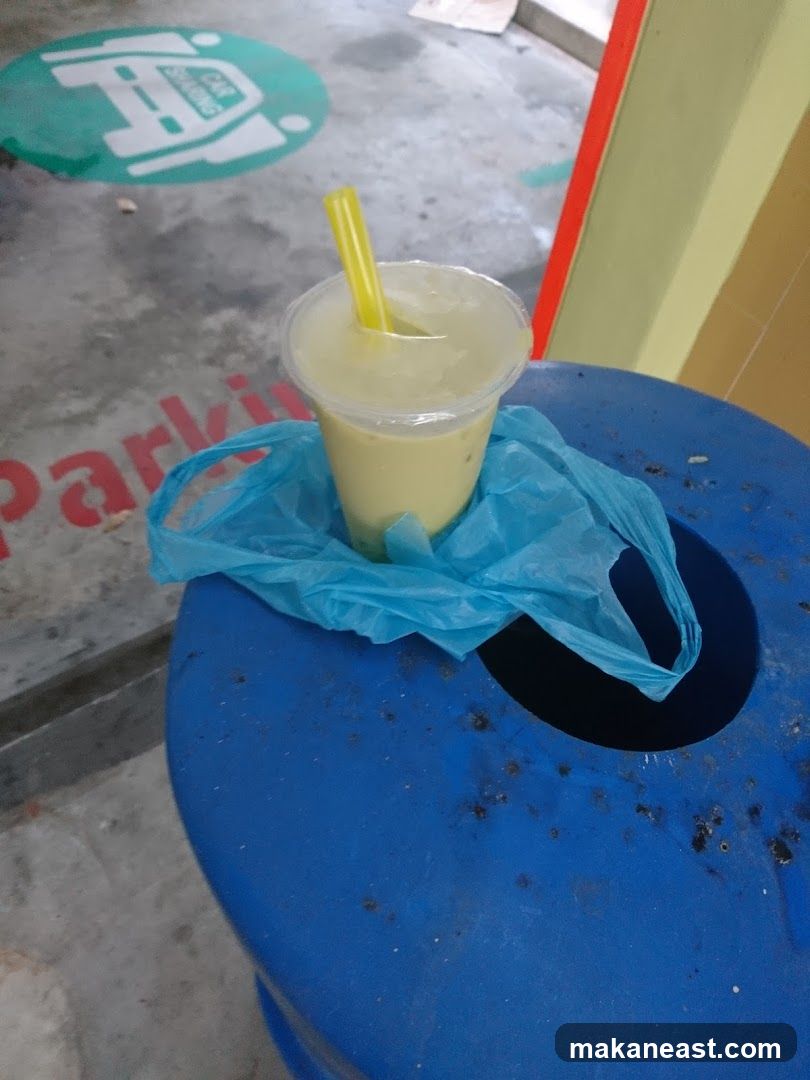 Drink in a plastic cup on a bin
