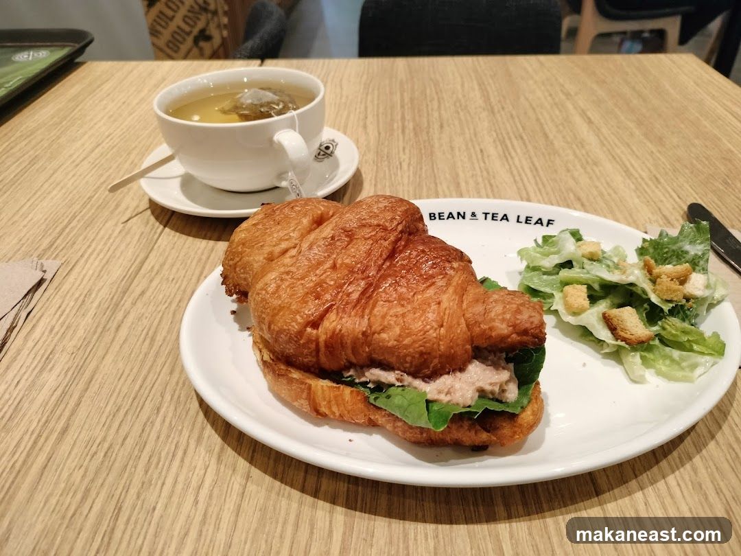 Croissant sandwich with salad and tea