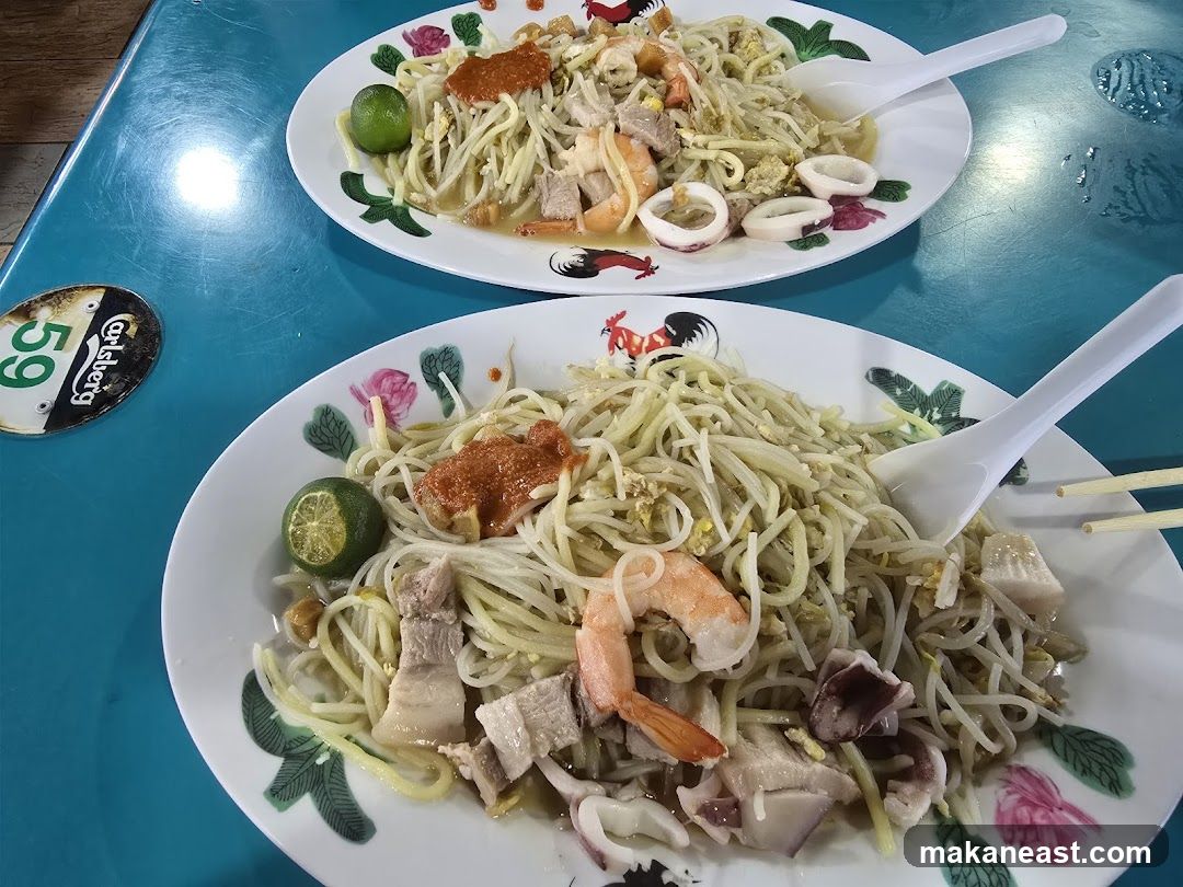 Two plates of noodles with seafood