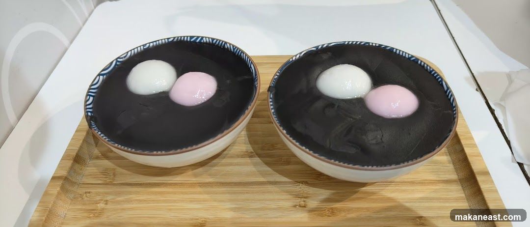 Two bowls of black sesame soup with mochi