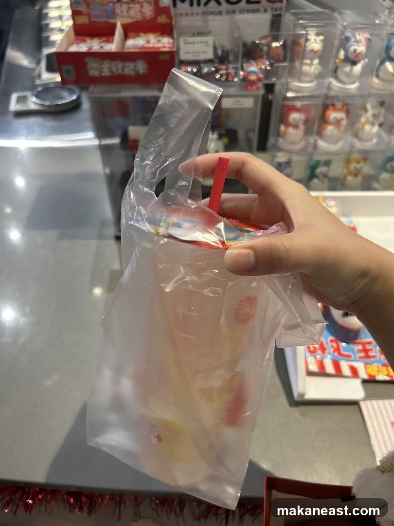 Hand holding a drink in a plastic bag
