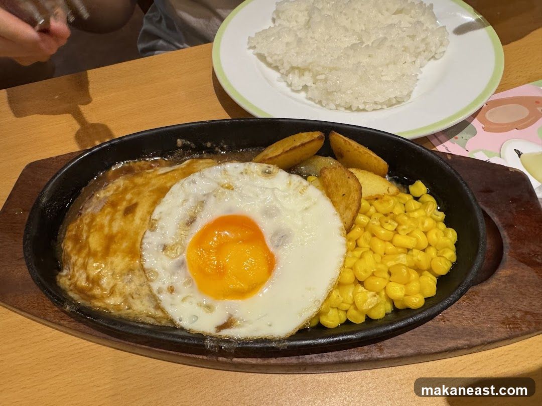 Hamburger steak with fried egg, corn, and potatoes