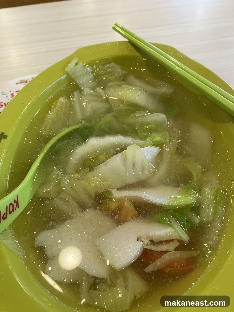 Bowl of Soup with Vegetables and Slices of Fish