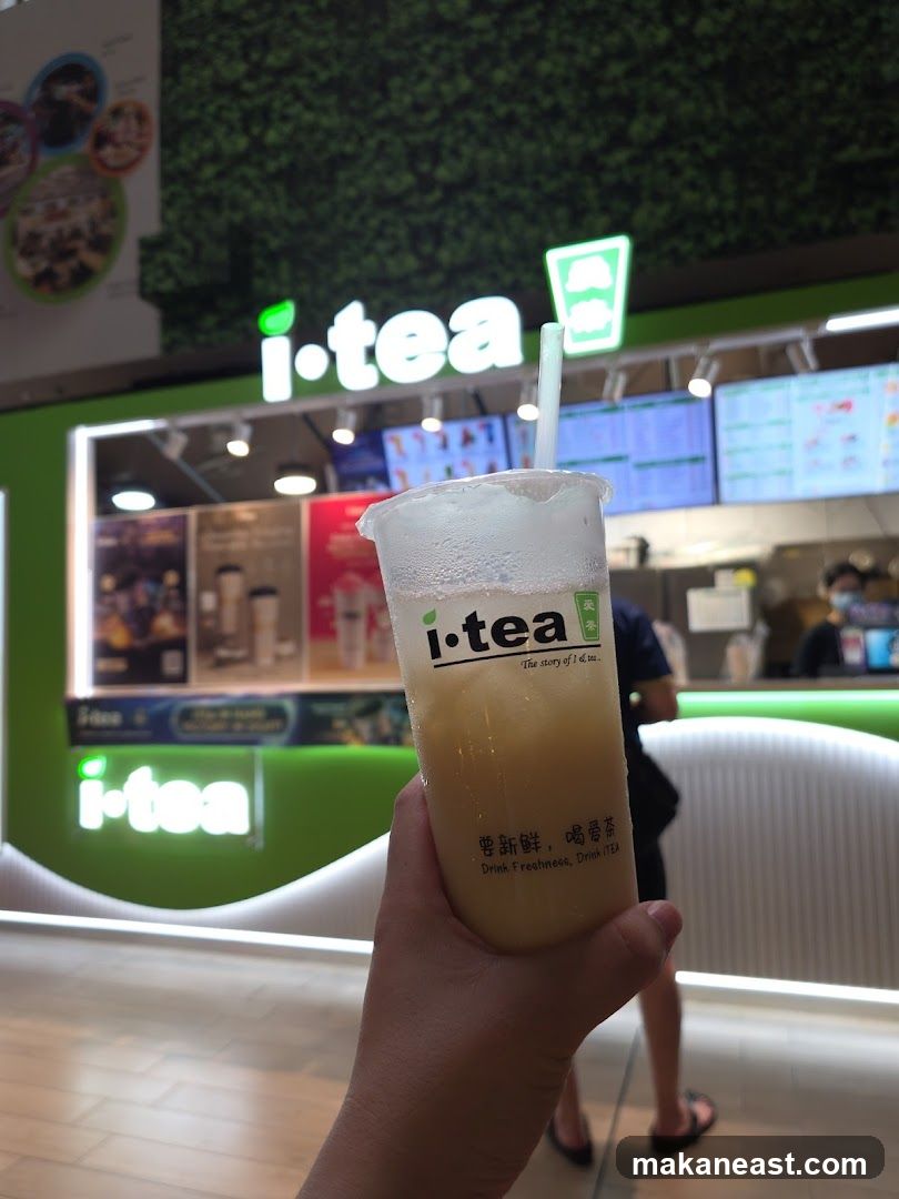 Person holding a drink in front of an i-tea shop
