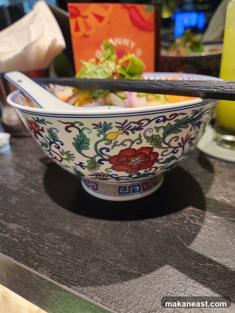 Bowl of food with chopsticks and spoon