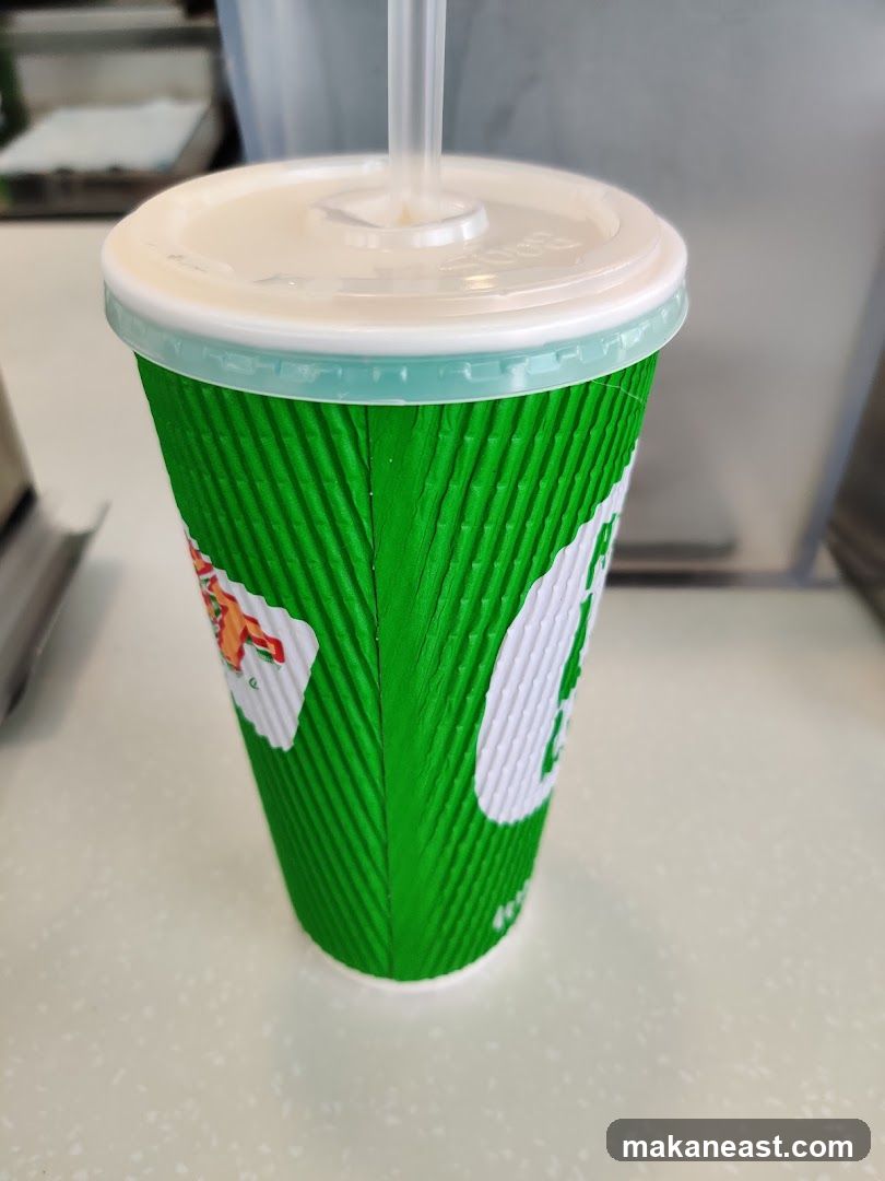 Green paper cup with a straw
