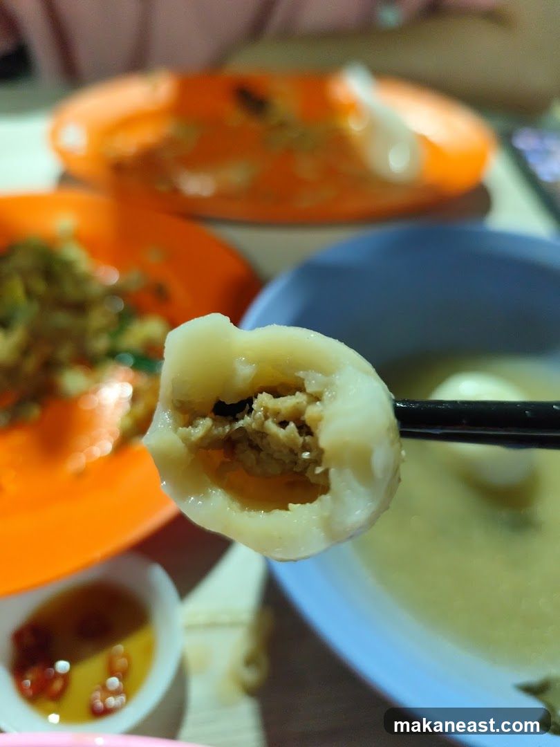 Close-up of a dumpling being held by chopsticks