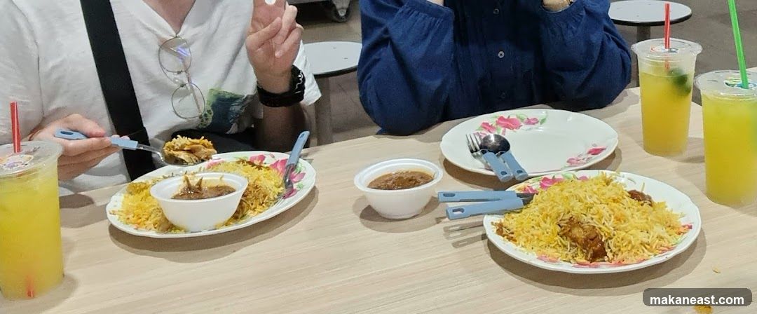 People eating biryani with drinks