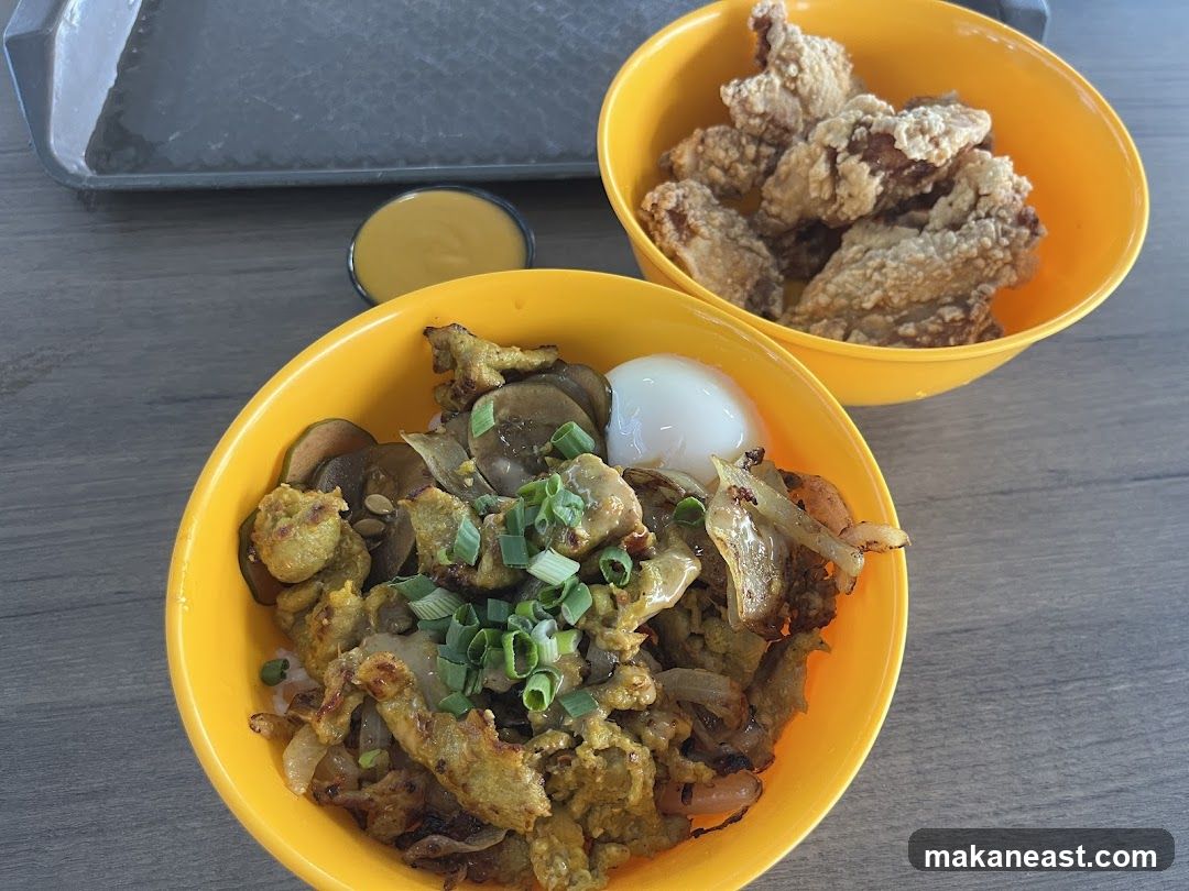 Two bowls of food with a side of sauce