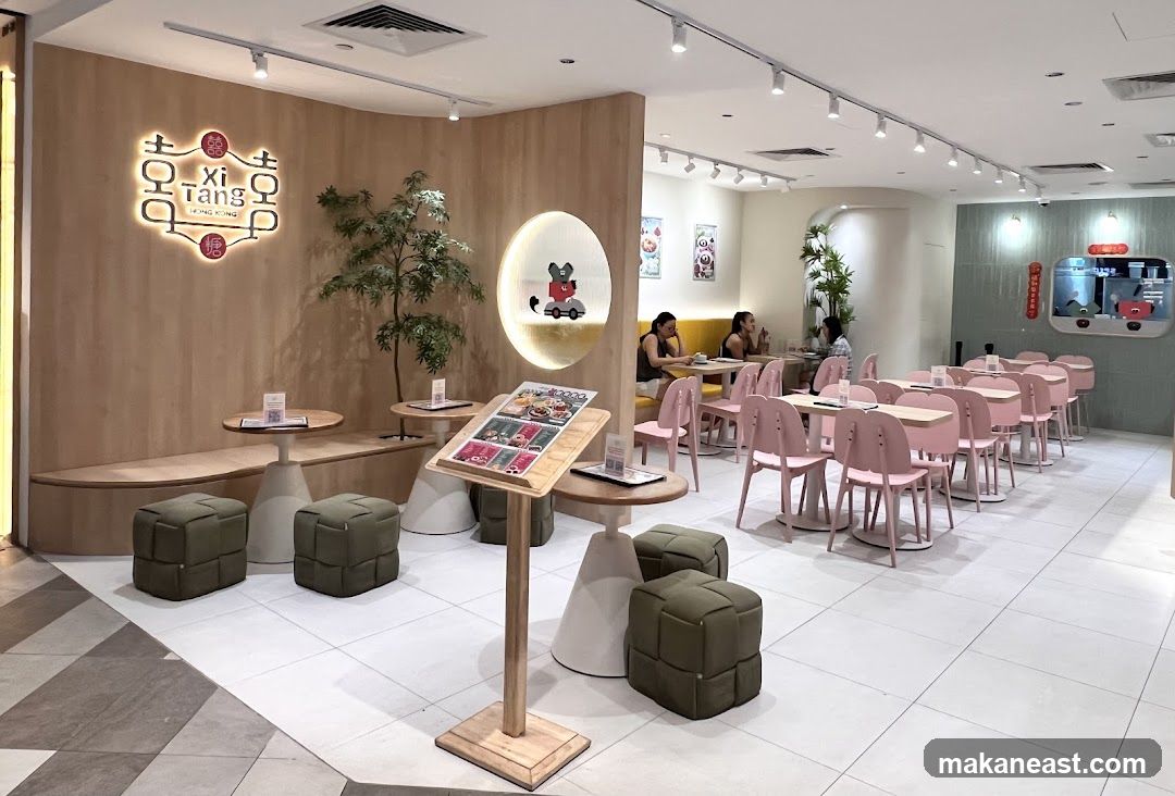 Modern cafe interior with pink chairs and wooden accents