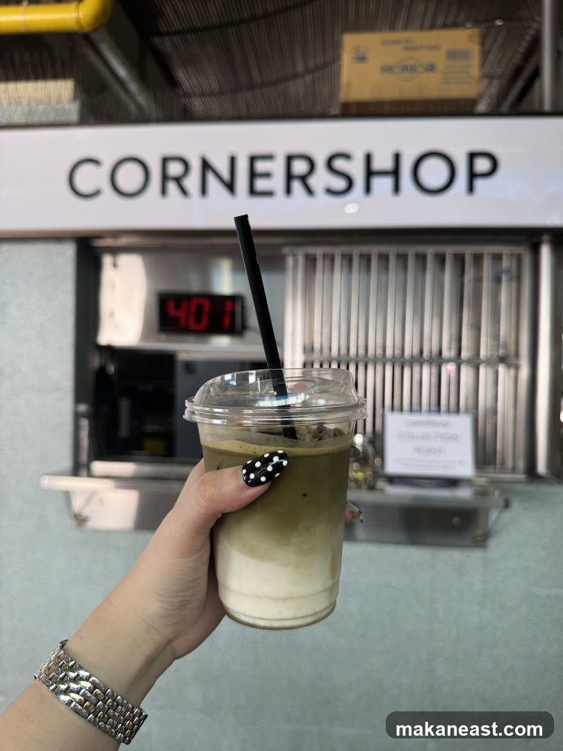 Person holding a drink in front of a shop counter