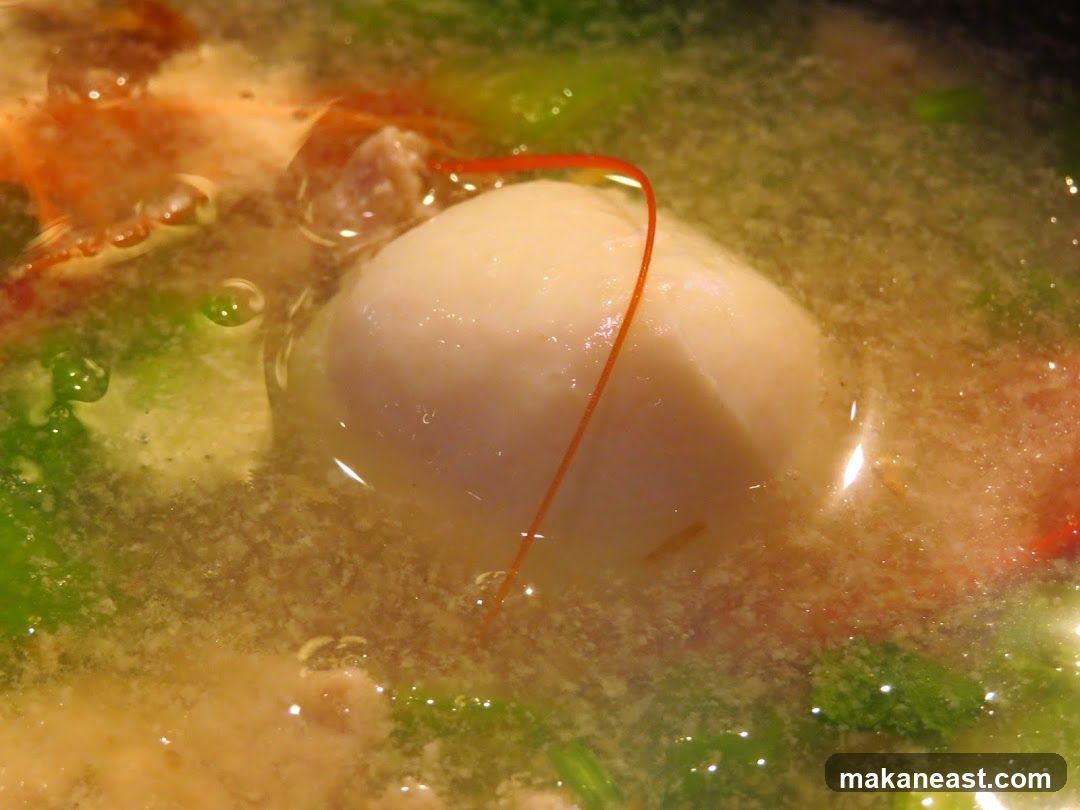 Close-up of a bowl of soup with a poached egg