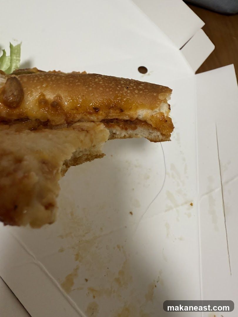 Half-eaten sandwich in a takeout box