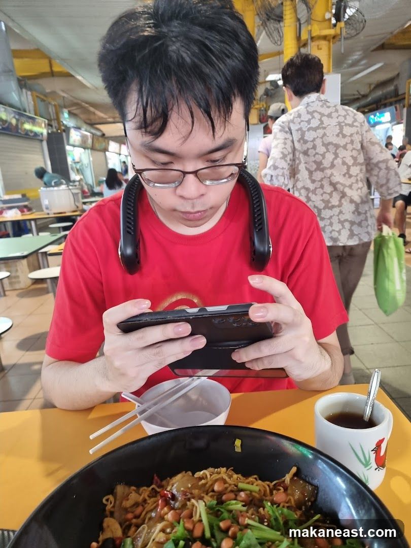 Man playing on phone at food stall
